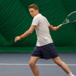 テニスをする青年