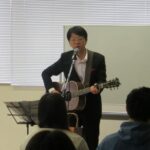 講演会で歌う石川