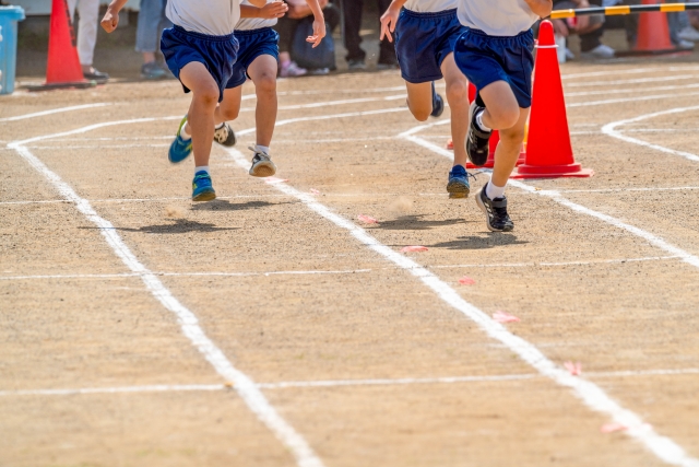 運動会で走る子どもの足の画像