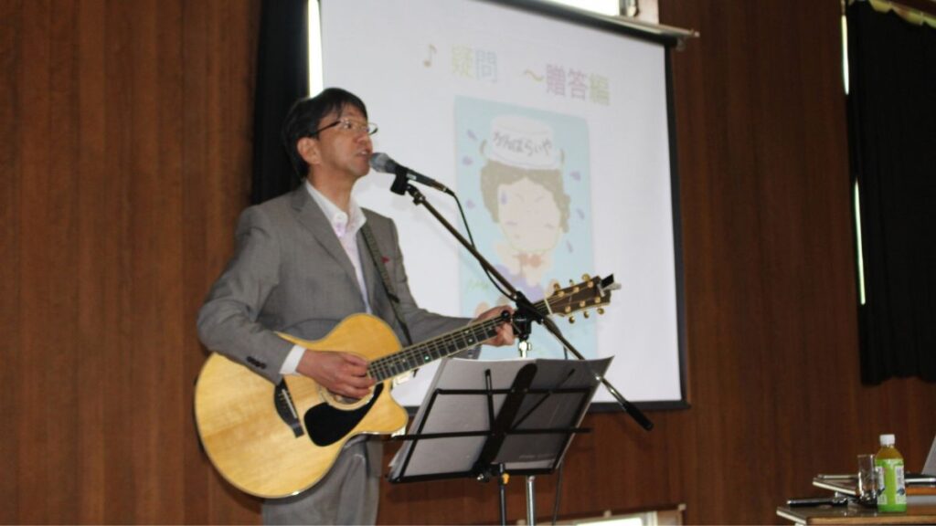 箕蚊屋中学校の人権講演会で歌う石川達之