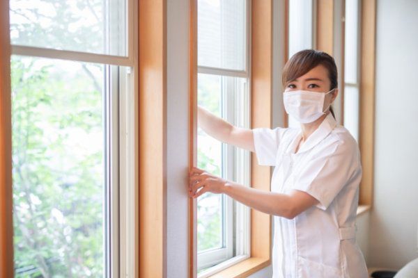 窓の掃除をする若い女性