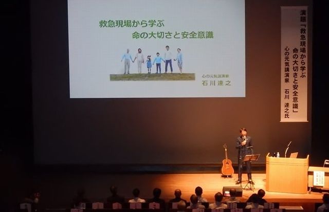 日田市民会館のステージで講演する石川