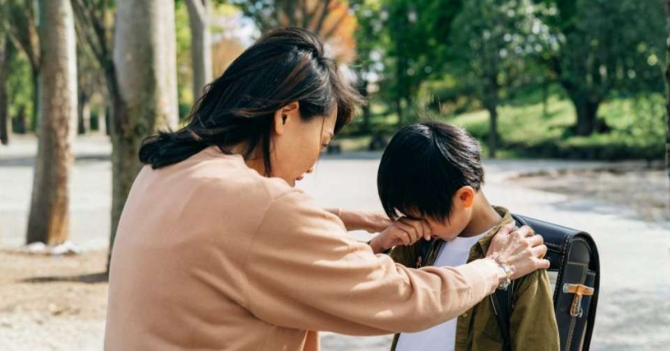 お母さんに叱られる小学生