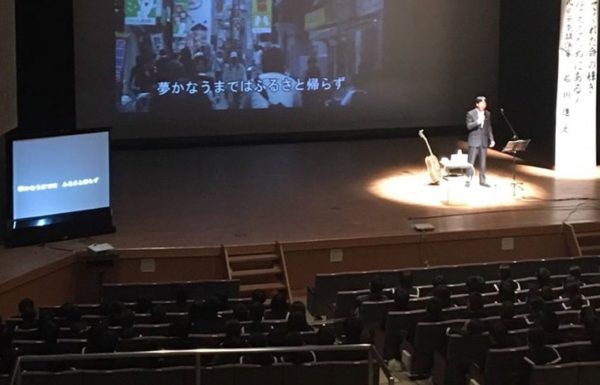 山口県和気町の人権講演会のステージで話す石川