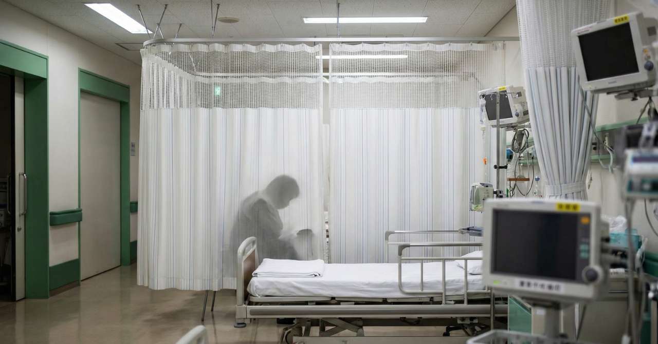 病院に収容されベッドに横たわる妻に話しかける夫