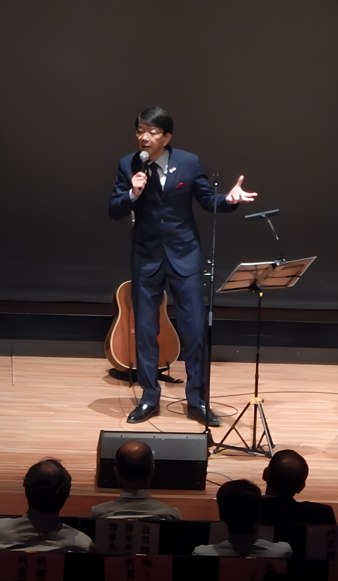 講演会のステージで話す石川達之