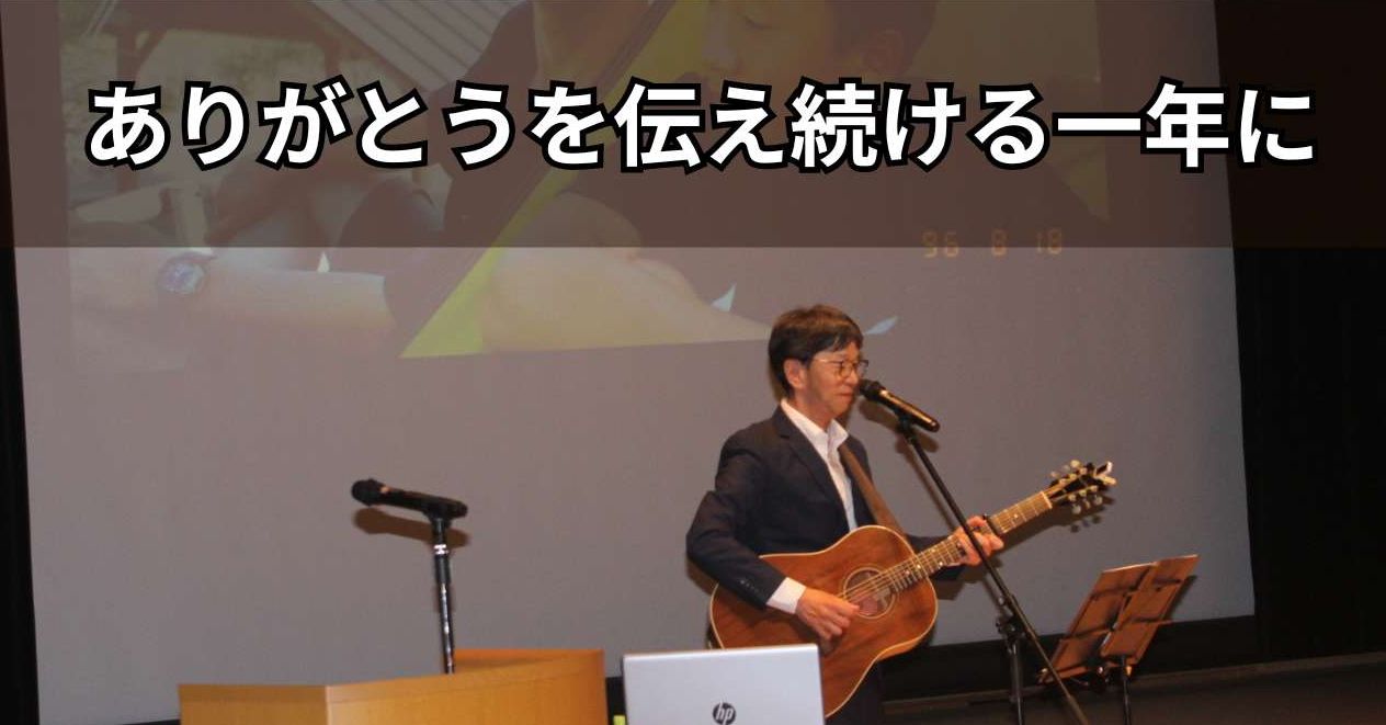 スライド画面をバックに歌う石川