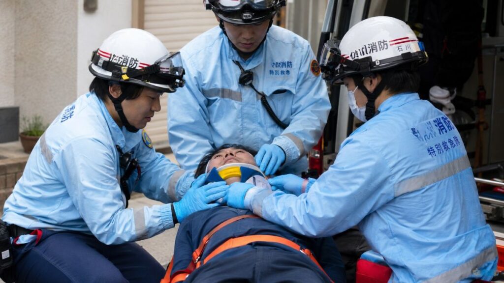墜落してケガをした人の頸部を固定する救急隊員