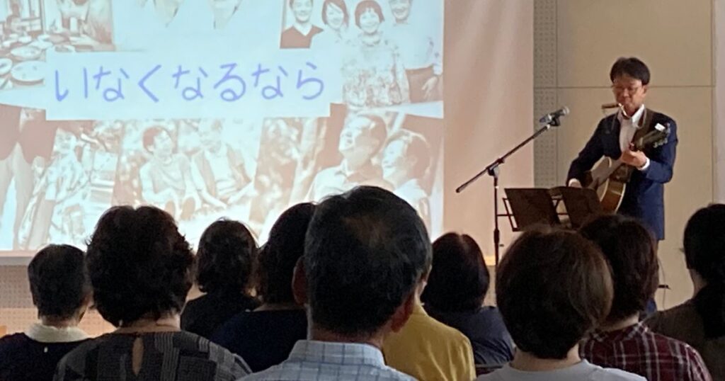 講演で歌う石川達之